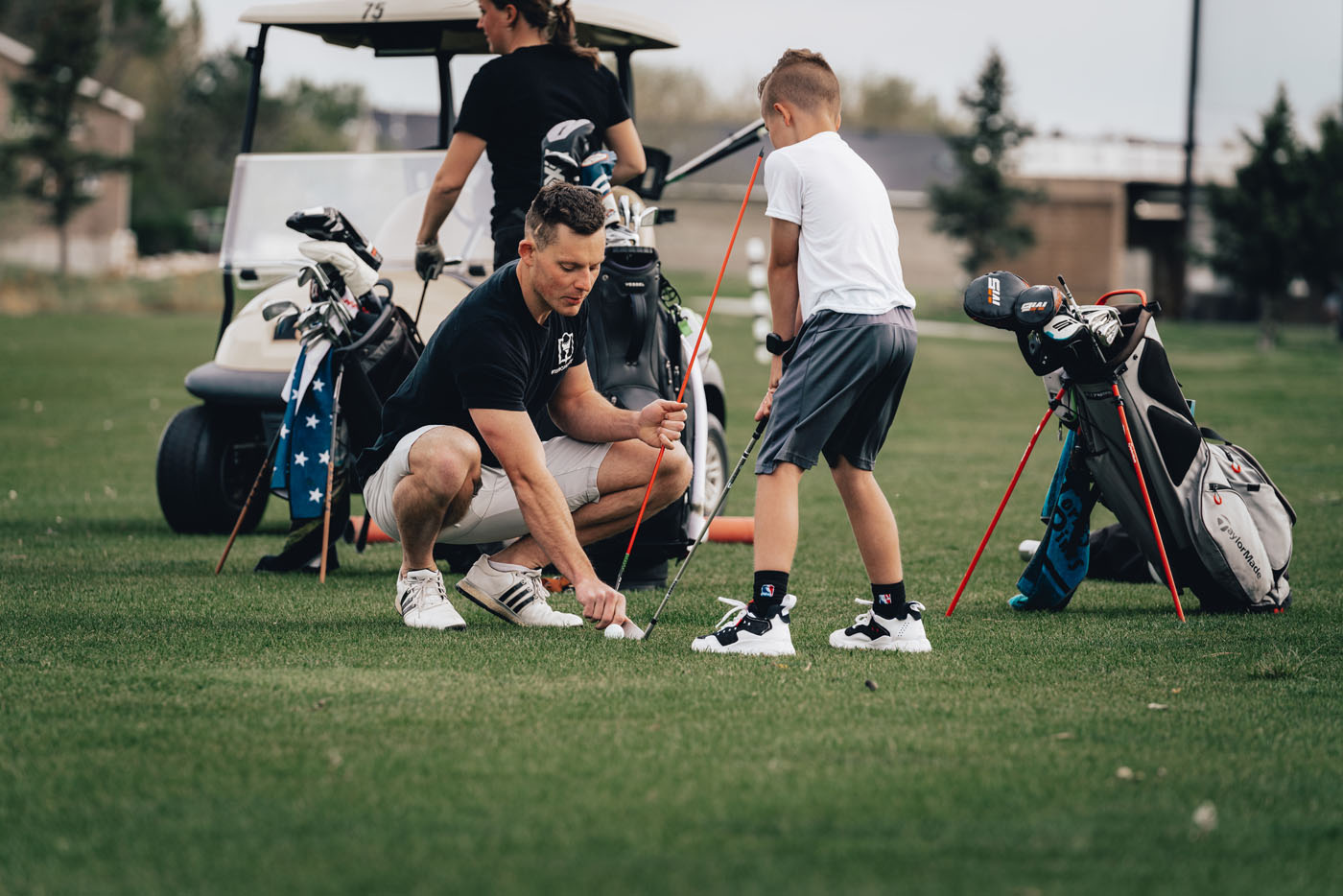 A Tee Box employee working with a group of kids on a golf course in Charlotte, NC.